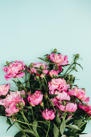 Beautiful pink peonies flowers bouquet on pale blue background. Flat lay, top view flowers pattern.の写真素材