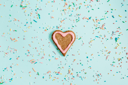 Colorful hand made cookie and confetti on blue background. Flat lay, top view.の写真素材