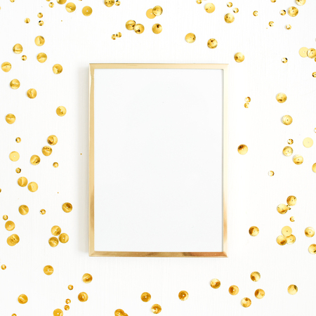 Photo frame mock up with space for text and golden confetti tinsel  on white background. Flat lay, top view. Minimal background.の写真素材