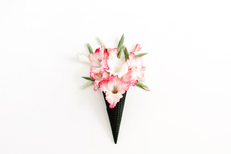 Black ice cream waffle cone with dry pink gladiolus flowers isolated on white background. Flat lay, top view flower concept.の写真素材