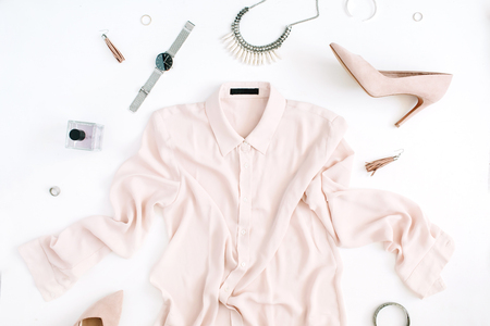 Women modern fashion clothes and accessories. Flat lay female casual style look with pastel blouse, high heels, watch, perfume. Top view.の写真素材