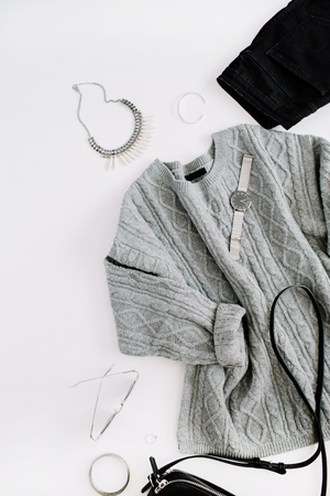 Women fashion cloth and accessories. Flat lay female casual style look with warm sweater, jeans, purse, watch, sunglasses. Top view.の写真素材
