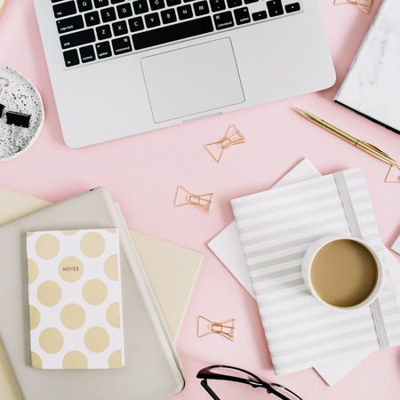 Flat lay modern workspace with laptop, notebook and stationery on pastel pink background. Top view. Golden style lifestyle concept.の写真素材