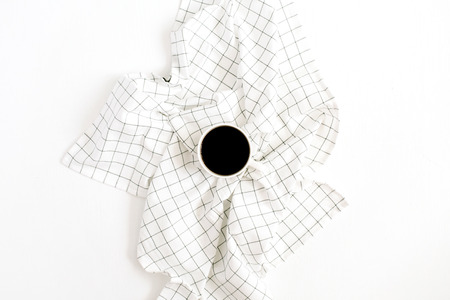 Coffee mug on cloth isolated on white background. Flat lay, top view minimal concept.の写真素材