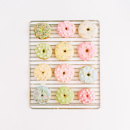 Colorful donuts on baking tray. Flat lay, top view minimal pattern.の写真素材