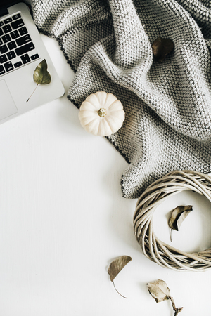 Flat lay composition. Workspace with laptop, white pumpkins, grey plaid and wreath frame. Top view autumn or winter concept.の写真素材