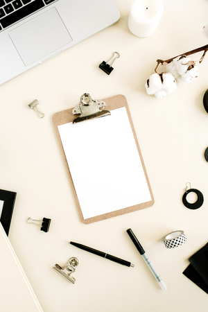 Flat lay home office desk. Workspace with clipboard, laptop on pastel beige background. Top view woman background.の写真素材