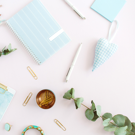 Flat lay home office desk. Female workspace with clipboard, diary, stationery on pale pink background. Top view feminine concept.の写真素材