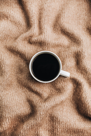 Coffee cup on brown wool background. Flat lay, top view.の写真素材
