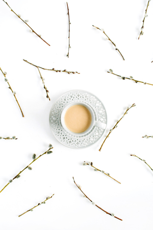 Cup of coffee with milk and willow branches pattern on white background. Flat lay, top view.の写真素材