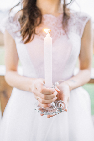 Young woman in evening dress holding candle. Wedding festive concept.の写真素材
