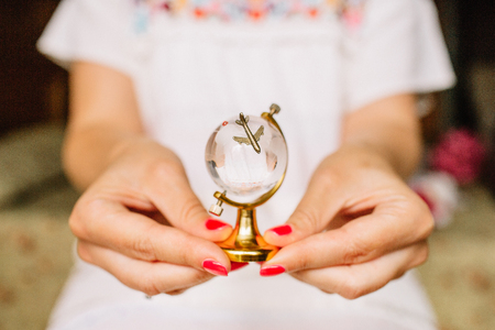 Young woman hands holding glass toy globe.の写真素材