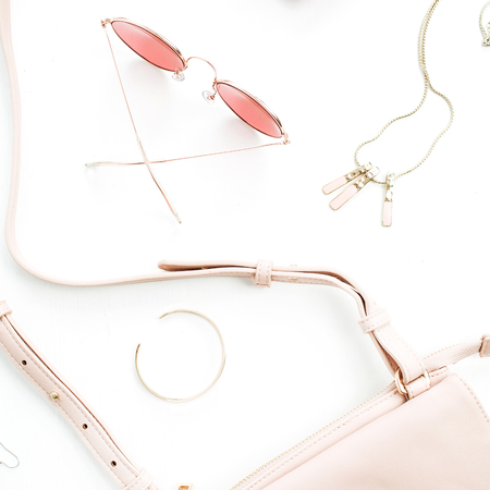 Pale pastel pink female accessory collection on white background. Flat lat, top view of sunglasses, clutch, necklace, bracelet, watch. Minimal concept.の写真素材