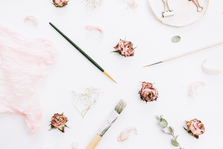 Creative wedding composition with rose flowers, eucalyptus branches and brushes on white background. Flat lay, top view stylish art concept.の写真素材