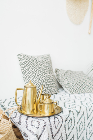 Modern minimal home interior design. Pillows, golden teapot, Scandinavian blanket.の写真素材