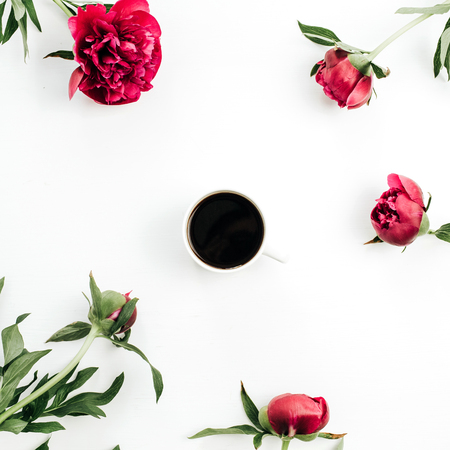 Coffee mug and pink peonies flowers on white background. Flat lay, top view.の写真素材
