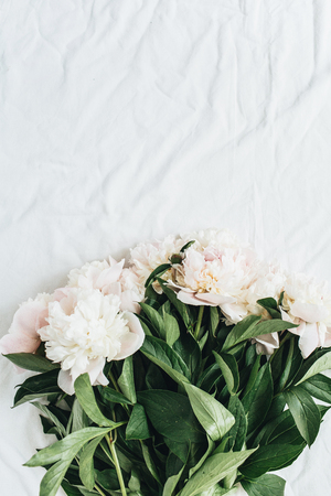Flat lay, top view of white peonies flower bouquet on white blanket background.の写真素材