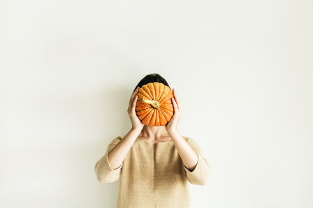 Young pretty woman holding halloween pumpkin on white background. Fall autumn concept.の写真素材
