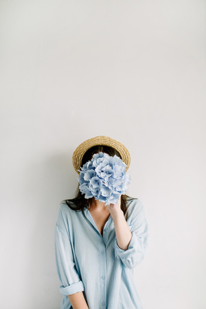 Young woman hold blue hydrangea flower bouquet on white background.の写真素材