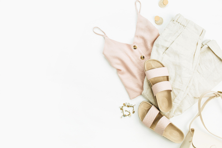 Flat lay, top view travel fashion look with woman clothes and accessories on white background. Female minimalist boho style concept.の写真素材