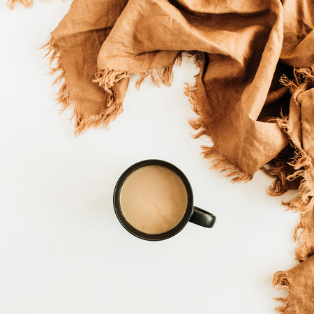 Mug of coffee with milk and ginger blanket on white background. Flat lay, top view.
