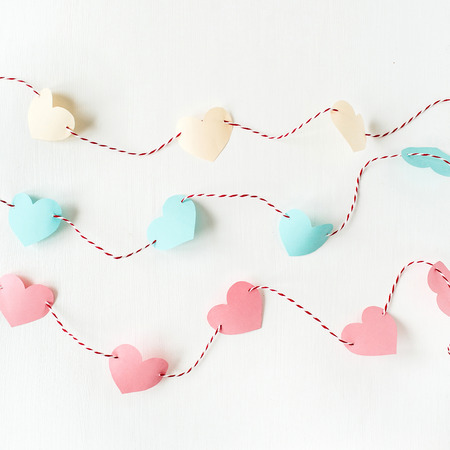 Flat lay, top view Valentines Day background with paper heart symbols and twine on white. Love concept.の写真素材