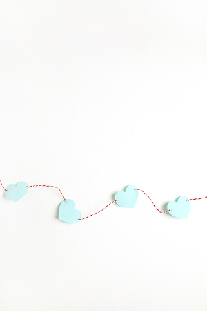 Flat lay, top view Valentines Day background with paper heart symbols and twine on white. Love concept.の写真素材