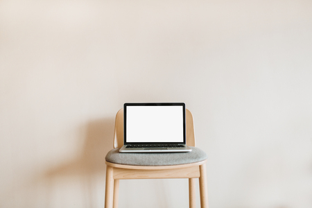 Laptop with mock up screen on wooden chair on pastel beige background. Blog, website, social media hero header template.の写真素材