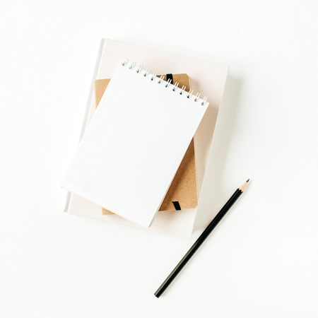 Minimalist office desk workspace with notebook on white background. Flat lay, top view blank paper copy space mock up.の写真素材