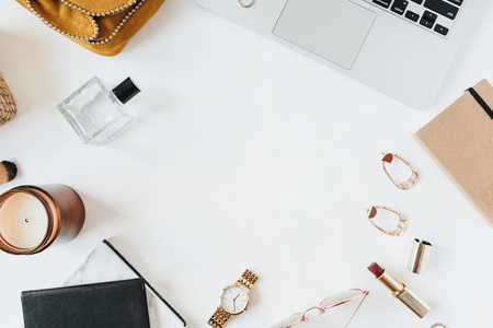 Round frame blank copy space mockup. Feminine modern home office desk workspace with laptop, perfume, watch, lipstick, brush, accessories on white background. Flat lay, top view. Fashion blog girl boss concept.の写真素材