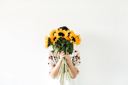 Young pretty woman with sunflowers bouquet on white background.の写真素材