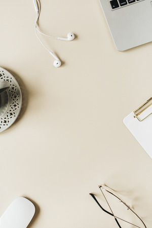 Round frame home office desk workspace with blank copy space mock up laptop, headphones, glasses, succulent on beige background. Flat lay, top view modern minimalist blog template.の写真素材
