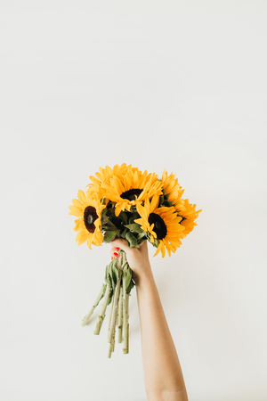 Sunflowers bouquet in women's hands. Flat lay, top view summer floral composition.の写真素材