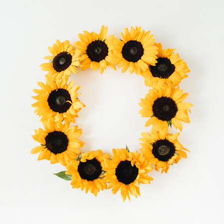 Wreath frame made of sunflowers with copy space on white background. Flat lay, top view summer floral mock up template.の写真素材