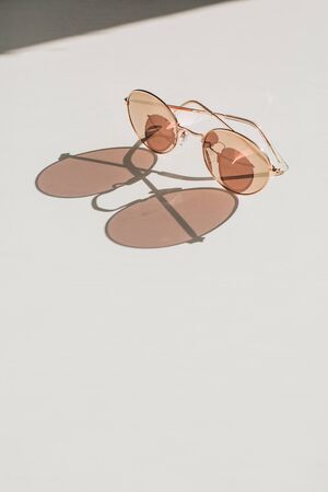 Modern women's sunglasses on white table. Modern minimal fashion blog hero header background.の写真素材
