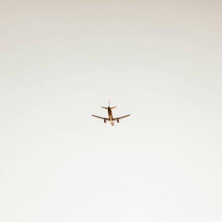 Airplane flying in the sky at sunset. Travel, vacation and holiday concept. Vintage and retro tones filter. Minimalistic background.の写真素材
