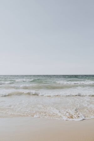 Beautiful tropical beach view with white sand and blue sea with waves on Phuket, Thailand. Minimal composition with neutral colors. Summer concept. Natural background.の写真素材