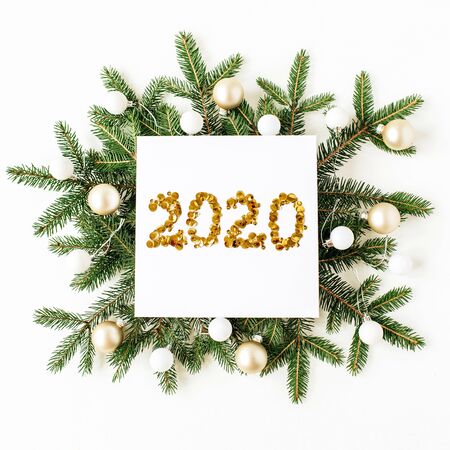 Christmas, New Year composition. Square frame with number 2020, Christmas baubles, fir needle branches on white background. Flat lay, top view festive holiday concept.の写真素材