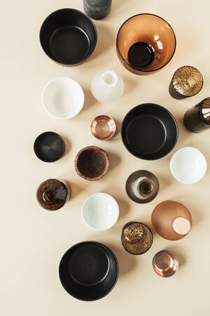 Many bowls, containers, saucers on pastel beige background. Flat lay, top view of wooden, ceramic, glass decorations.の写真素材