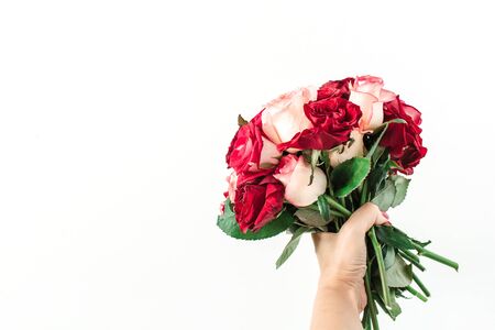 Female hand hold pink and red rose flowers bouquet isolated on white background. Holiday, Valentine's day present.の写真素材