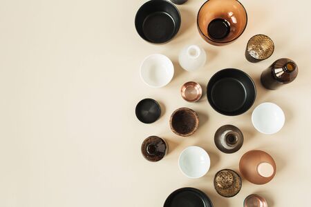Many bowls, containers, saucers on pastel beige background. Flat lay, top view of wooden, ceramic, glass decorations.の写真素材