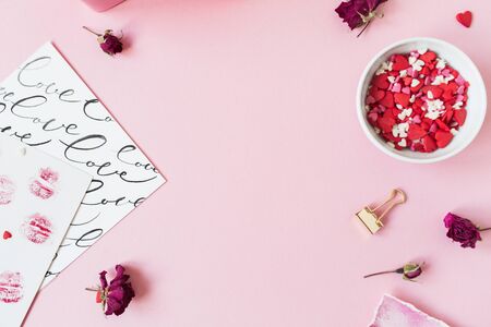 Valentine's Day composition. Blank copy space frame on pink background. Gift box, rose buds, heart...
