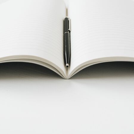 Open notebook with pen on white background.の写真素材