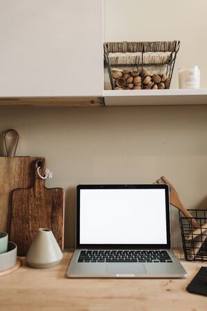 Workspace with mockup blank copy space screen laptop in kitchen. Modern stylish interior design. Front view blog, social media, website hero header template.の写真素材