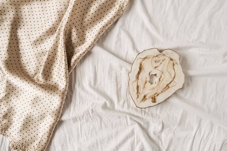 Marble tray and silk polka-bot cloth on white linen. Minimal flat lay, top view fashion concept.の写真素材