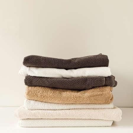 Folded towels stack on white background. Health care, hygiene, wellness composition.の写真素材