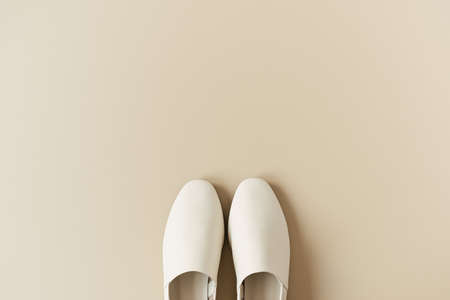 Fashion collage with women's white leather slippers on neutral beige. Minimal flat lay, top view lifestyle concept.の写真素材
