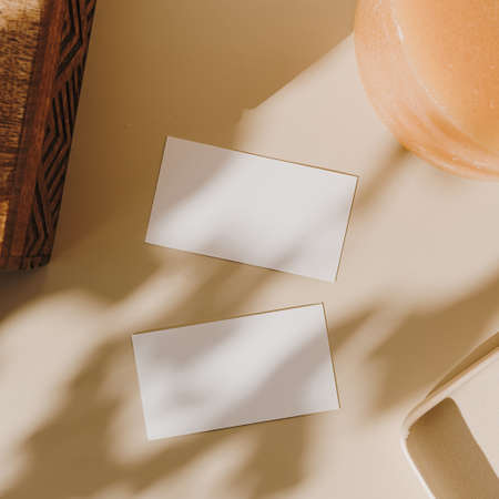 Blank paper sheet cards with mockup copy space, wooden casket and candle with sunlight shadow on...