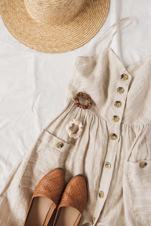 Beauty fashion collage with women's clothes and accessory on white linen. Sun dress sarafan, leather shoes, straw hat. Flat lay, top view fashion blog lifestyle conceptの写真素材