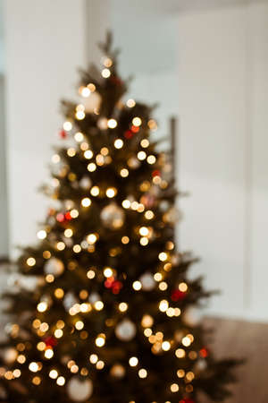Blurred lights on Christmas tree. Bright glow gold bokeh. Reflections of Christmas lights. Glowing lights.の写真素材